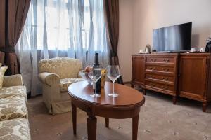 ein Wohnzimmer mit einem Tisch und 2 Gläsern Wein in der Unterkunft Hotel Stara Lika in Gospić