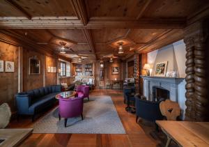a living room filled with furniture and a fire place at Hotel Stoffel - adults only in Arosa