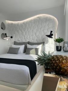 a bedroom with a large white bed with a pineapple at Studios Panos in Naxos Chora