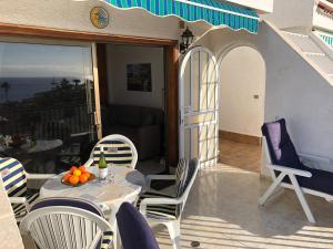 Un patio con una mesa y sillas en un balcón. en Appartment Teneriffa Tamara Anlage, en Santiago del Teide