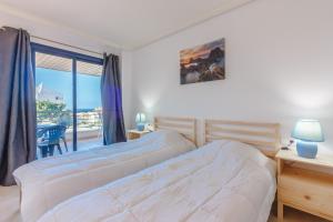 une chambre avec deux lits et un balcon dans l'établissement Balcon de Los Gigantes 2A037, à Puerto de Santiago 34 autres photos