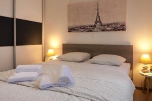 ein Schlafzimmer mit einem Bett mit Handtüchern und dem Eiffelturm in der Unterkunft MARIN 1 in Kaštela