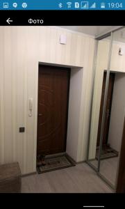 Cette chambre dispose d'une porte marron et d'un miroir. dans l'établissement Новобудова.Центр.Перемоги, à Loutsk