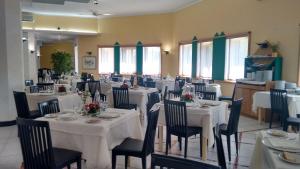 uma sala de jantar com mesas e cadeiras brancas em Villaggio Turistico La Mantinera - Appartamenti de Luxe em Praia a Mare
