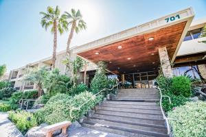 una scala che conduce a un edificio con palme di Palm Springs Tennis Club, a VRI resort a Palm Springs