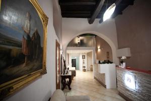 einen Flur mit einem Gemälde an der Wand und ein Wohnzimmer in der Unterkunft Le Due Sicilie in Tropea