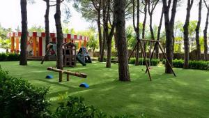 a playground with trees and swings in a park at Villaggio Turistico La Mantinera - Appartamenti de Luxe in Praia a Mare