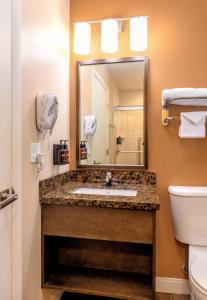 a bathroom with a sink, toilet and mirror at Boulder University Inn in Boulder