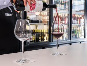 a person pouring wine into two wine glasses at Hotel Voramar in Benidorm