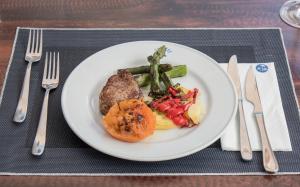 a plate of food with meat and vegetables on a table at Hotel Voramar in Benidorm