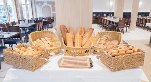 three baskets of bread on a table in a restaurant at Hotel Voramar in Benidorm