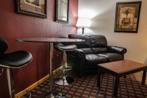 a hotel room with a table and a leather chair at Harrington Inn in Fremont