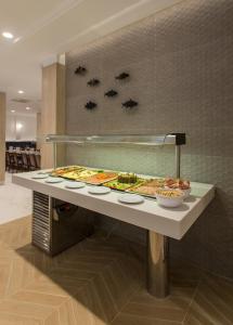 a buffet of pizzas on a counter in a restaurant at Hotel Voramar in Benidorm