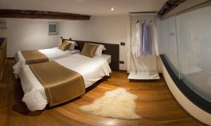 1 Schlafzimmer mit 2 Betten und einem großen Fenster in der Unterkunft Triangolo D'oro in Genua