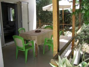 a table with green chairs and an umbrella on a patio at NIKOS in Kakovatos