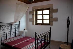 a bedroom with a black bed and a window at SPITI MAS in Proástion