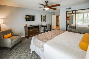 1 dormitorio con 1 cama, 1 silla y TV en Palm Springs Tennis Club, a VRI resort, en Palm Springs