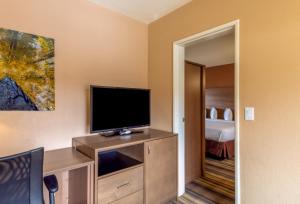 a hotel room with a flat screen tv on a dresser at Boulder University Inn in Boulder