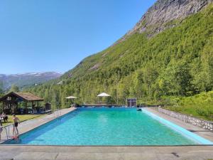 a large swimming pool in front of a mountain at Voss Mountain Lodge in Mjølfjell