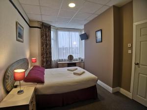 Habitación de hotel con cama y ventana en The Hopton Hotel, en Blackpool