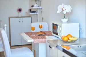 a kitchen with two glasses of wine and a microwave at Studio Kristic in Dubrovnik