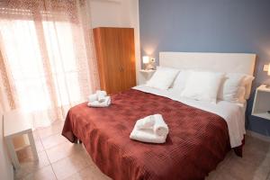 a bedroom with a large bed with towels on it at B&B New Triscele in Sciacca