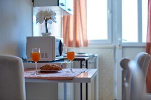 a table with two glasses of orange juice and a plate of food at Studio Kristic in Dubrovnik