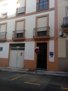 un edificio in una strada con un cartello stradale di fronte di Casa Turistica Termas aparcamiento y desayuno incluido a Mérida