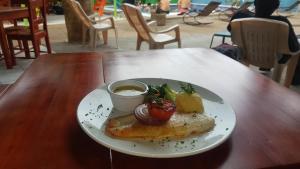 a plate of food on a wooden table at Hotel La Arboleda in Managua