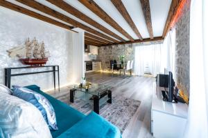 uma sala de estar com um sofá azul e uma televisão em Apartment 4 You em Dubrovnik