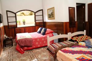 1 dormitorio con 2 camas y ventana en Pousada Sol Da Montanha, en Jardim Sun Valley