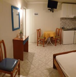 a kitchen and dining room with a table and a kitchen and a room at Epi Apartments in Lourdhata