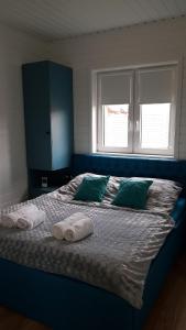 ŁebczにあるDomek Cyprusのベッドルーム1室(ブルーベッド1台、タオル付)
