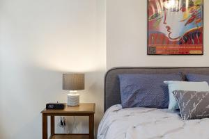 a bedroom with a bed and a table with a lamp at Halsey Haven - Center Of Downtown Arts District Apts in Newark