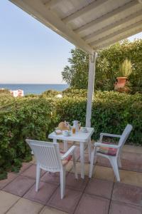 a white table and chairs on a patio with the ocean at Yolanda Studios in Paralia Agias Foteinis