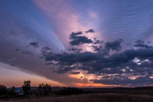 um céu nublado ao pôr-do-sol num campo em Rocky Ridge Country Lodge em Mountain View