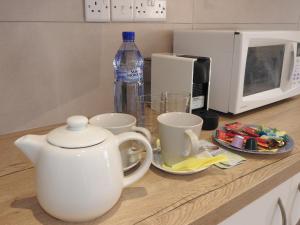 a kitchen counter with cups and a bottle of water at Hill View Hotel Apartments in Pissouri