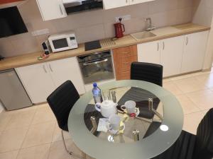a kitchen with a glass table and black chairs at Hill View Hotel Apartments in Pissouri