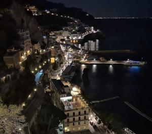 uma cidade à noite com luzes na água em Agriturismo A do' Cumparone em Corbara