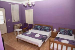 a bedroom with two beds and purple walls at Privatni Smještaj i Seoski Turizam "SUDAR" in Bizovac