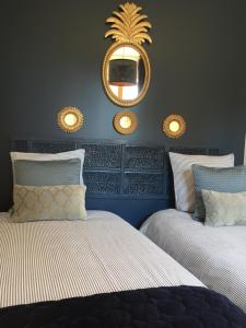 - une chambre avec 2 lits et un miroir mural dans l'établissement La Maison Au Bois Dormant, à Barraux