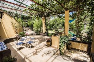 een patio met een tafel, stoelen en bomen bij b&b Lu Paradisu in Capo Mulini