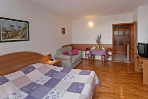 ein Schlafzimmer mit einem Bett, einer Couch und einem Tisch in der Unterkunft Korsa in Sveti Lovrec * Istrien in Sveti Lovreč Pazenatički