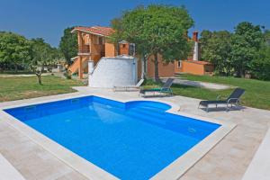 una piscina con 2 sillas y una casa en Vrtline in Krnica * Istrien, en Krnica