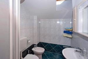 ein Badezimmer mit einer weißen Toilette und einem Waschbecken in der Unterkunft Korsa in Sveti Lovrec * Istrien in Sveti Lovreč Pazenatički + 18 Fotos