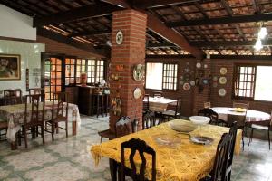 a dining room with a table and chairs in a building at Pousada Sol Da Montanha in Jardim Sun Valley