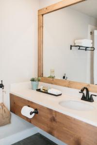 a bathroom with a sink, mirror and bath tub at Inn At Mount Shasta in Mount Shasta