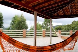 una hamaca en una terraza con una valla en Pousada Sol Da Montanha, en Jardim Sun Valley