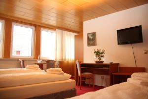 a hotel room with two beds and a desk at Hotel Garni Kaiserpfalz in Goslar