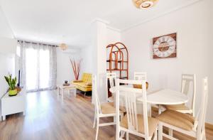 a white living room with a table and chairs at Pueblito La Zenia Beach in Orihuela Costa